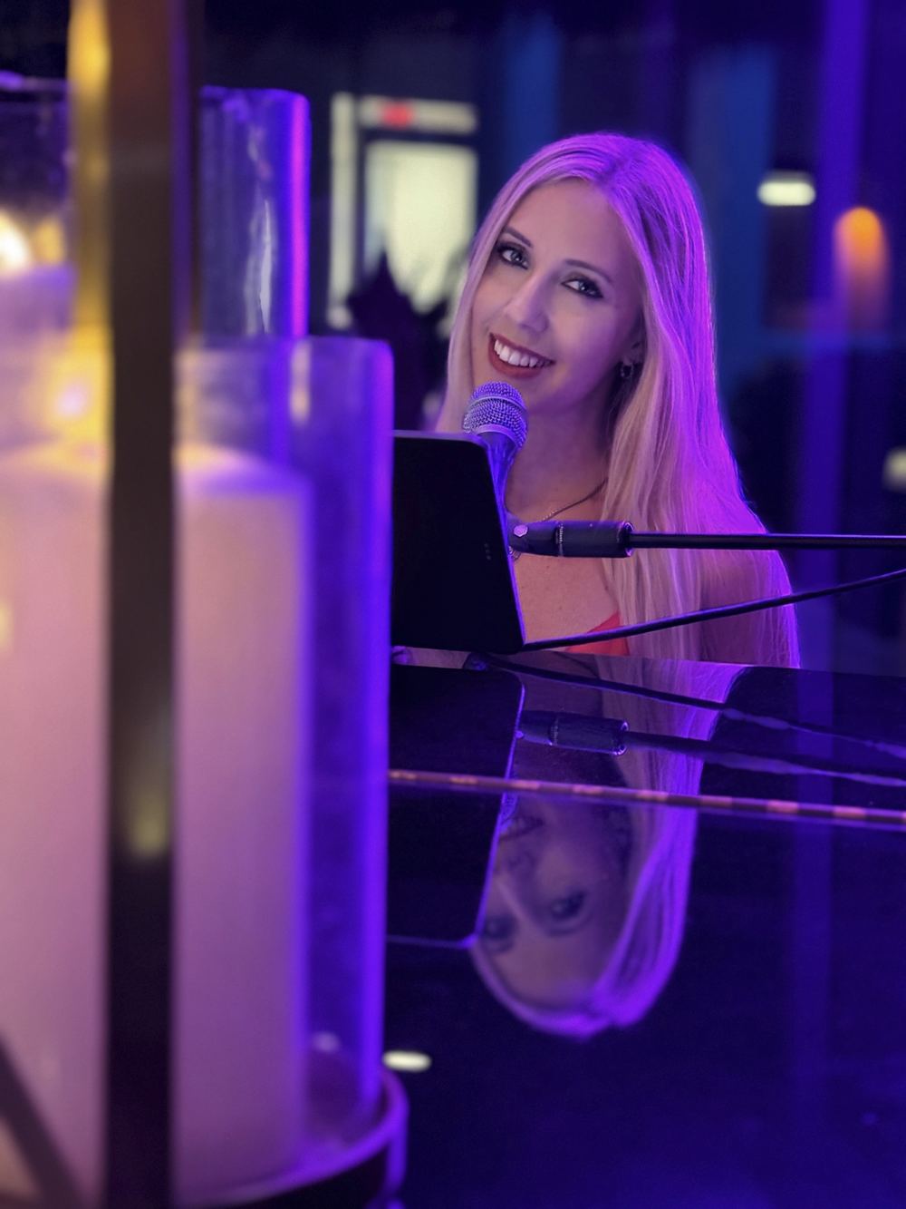 Joanna Holstein at the piano under violet event lighting