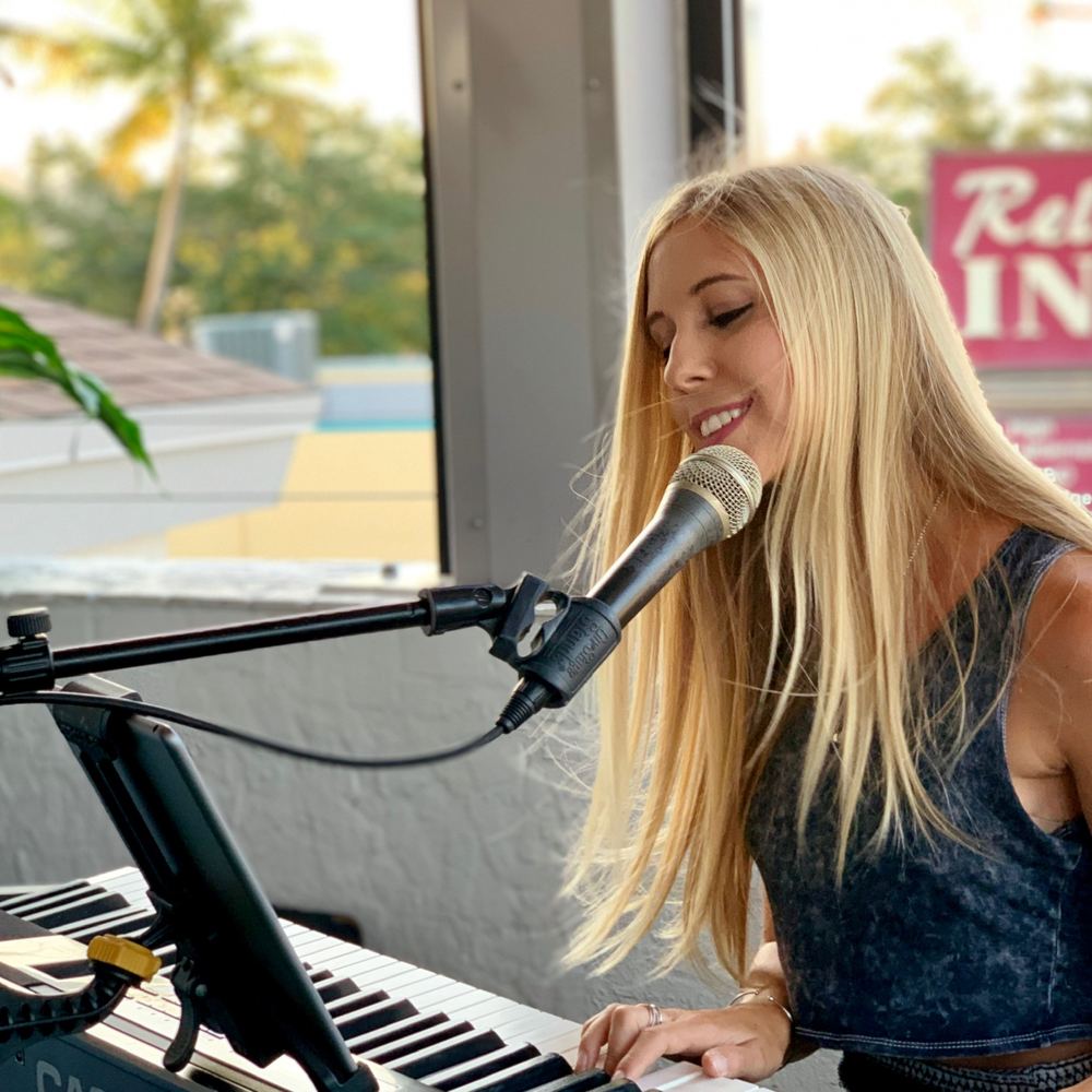 Joanna Holstein singing at a waterfront party
